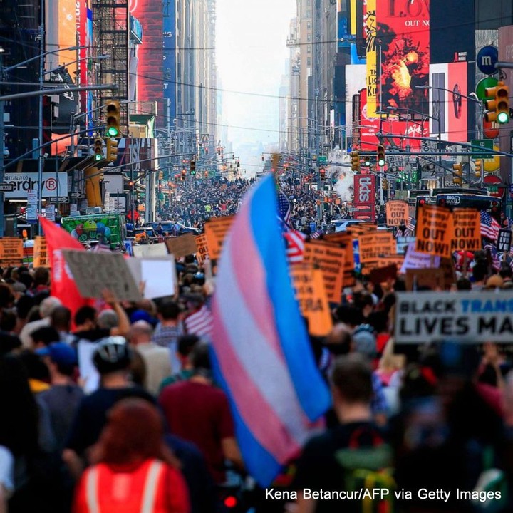 People march down 7th Avenue in New York City, stretching as far as the eye can ...