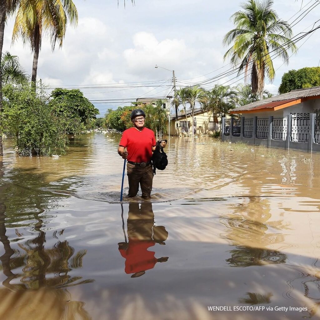 A man wades through the water in the flooded municipality of La Lima near San Pe...